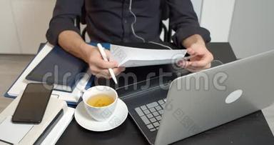 男士双手合拢，手拿着文件，在桌子旁的合同里做笔记